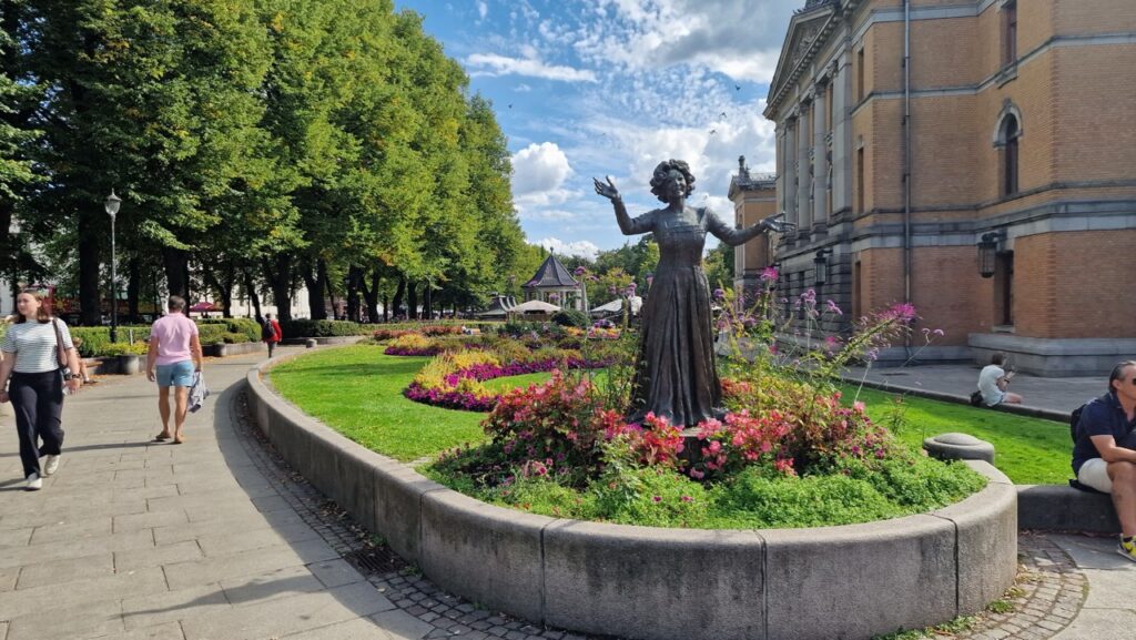 Wenke Foss szobra a Studenterlunden parkban, háttérben a Nationaltheatret